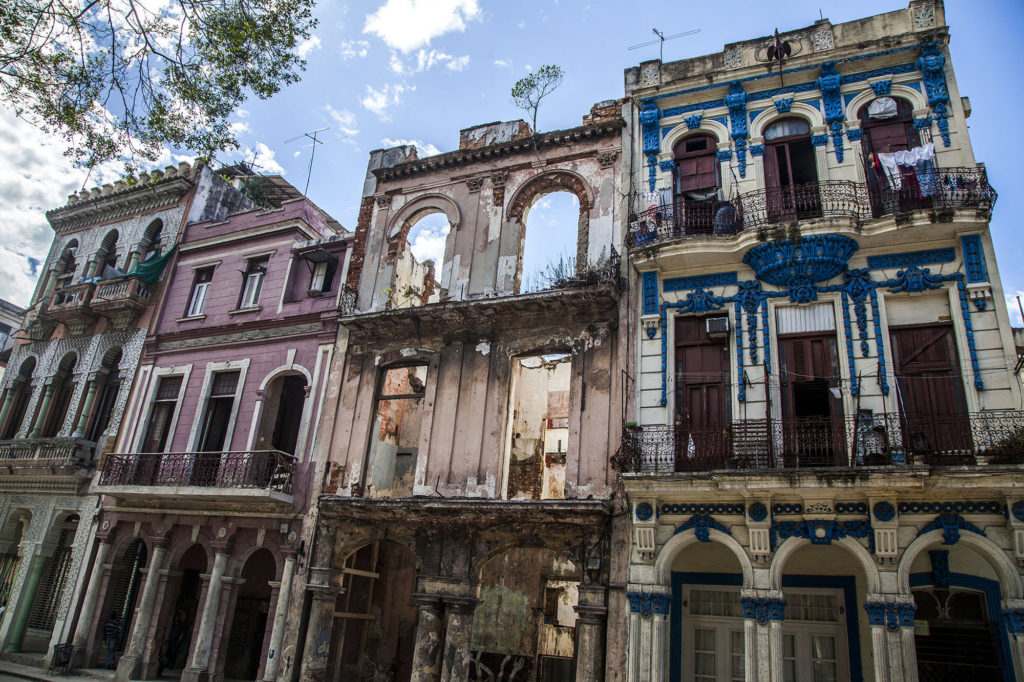 A crumbling building between preserved buildings in Havana Cuba