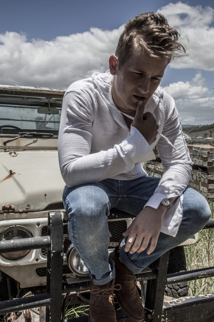 Jesse sitting on the end of an old ute