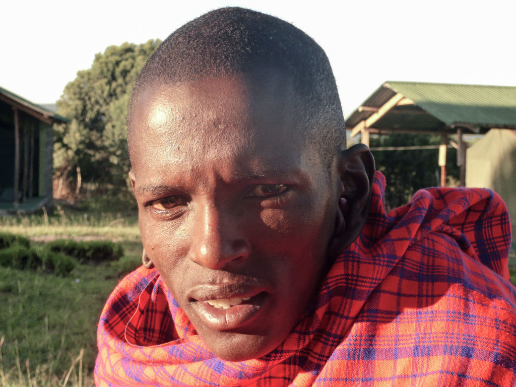 Maasai warrior dressed in traditional attire in the Masai Mara Kenya