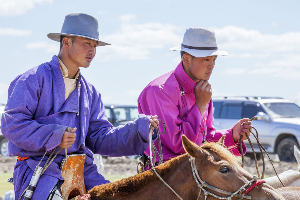 Brightly adorned Mongolian horse riders wearing deel