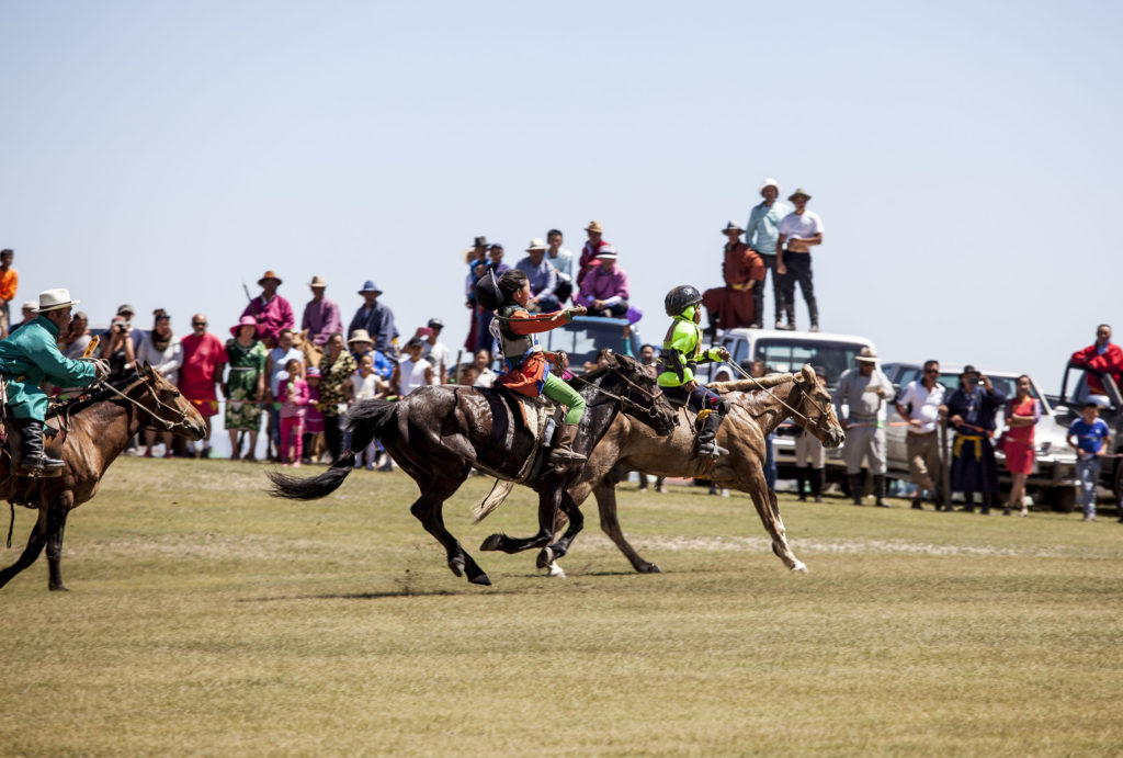 Young Mongolian riders horse racing at Naadam