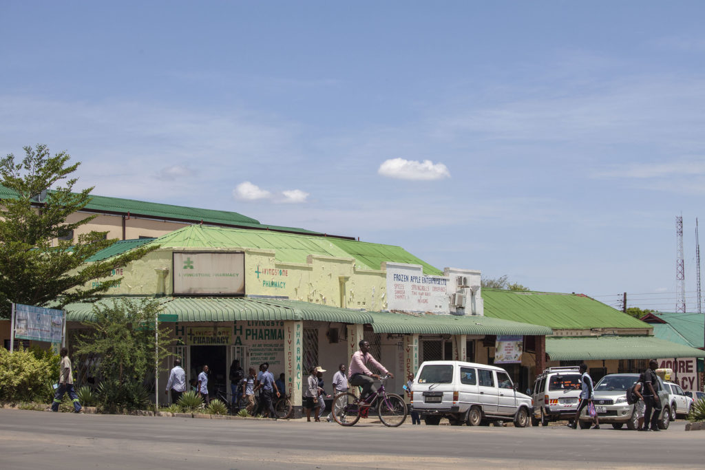 Man riding bicycle along avenue in Livingstone Zambia copy